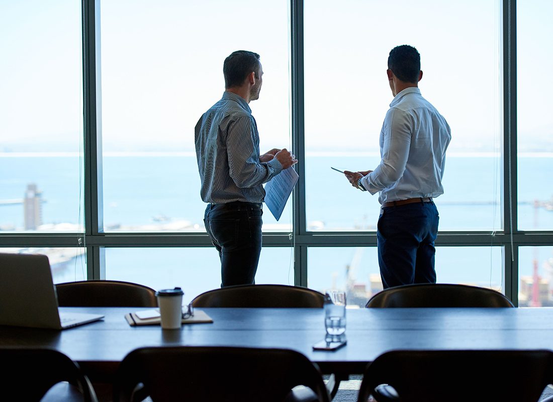 Insurance Solutions - Two Business Professionals Have a Meeting in an Office With an Ocean View
